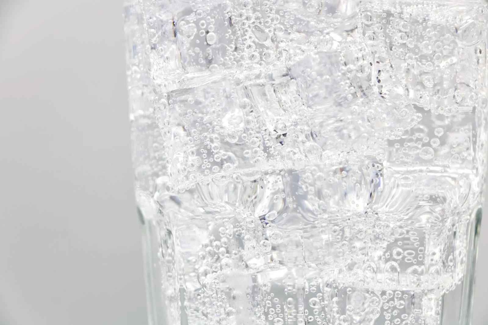 Close-up of sparkling water with ice in a glass, carbonated at home